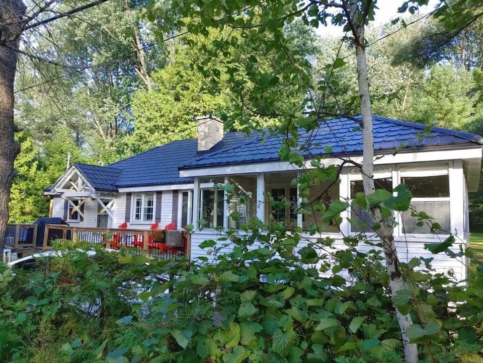 New metal roof and stone chimney with a front deck