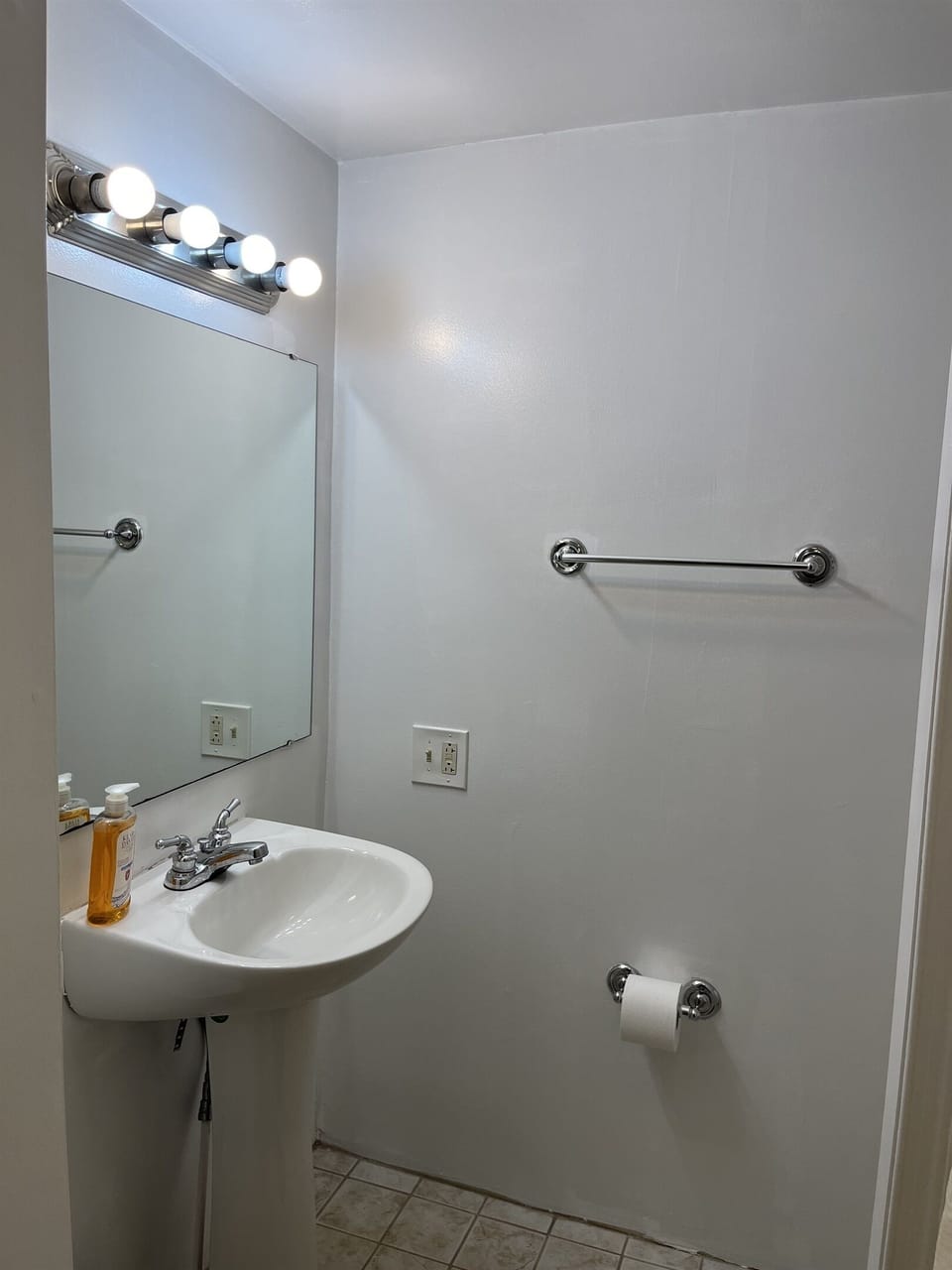 Full bathroom with shower located in corner of kitchen next to the laundry area.