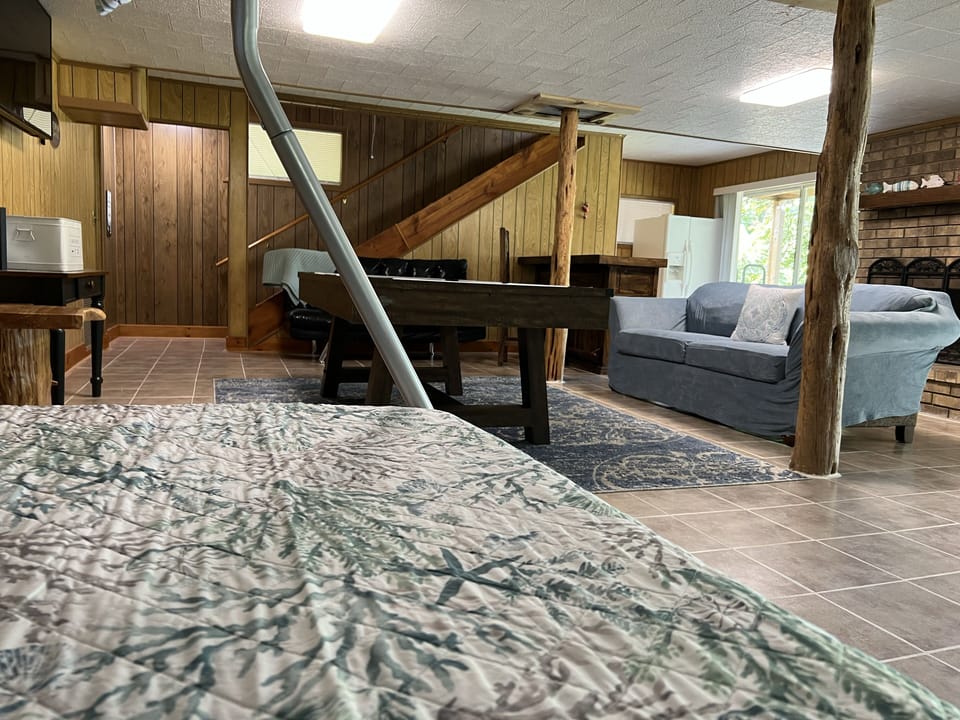 Downstairs game room with pool table, extra icebox, triple bunk, futon, & couch.