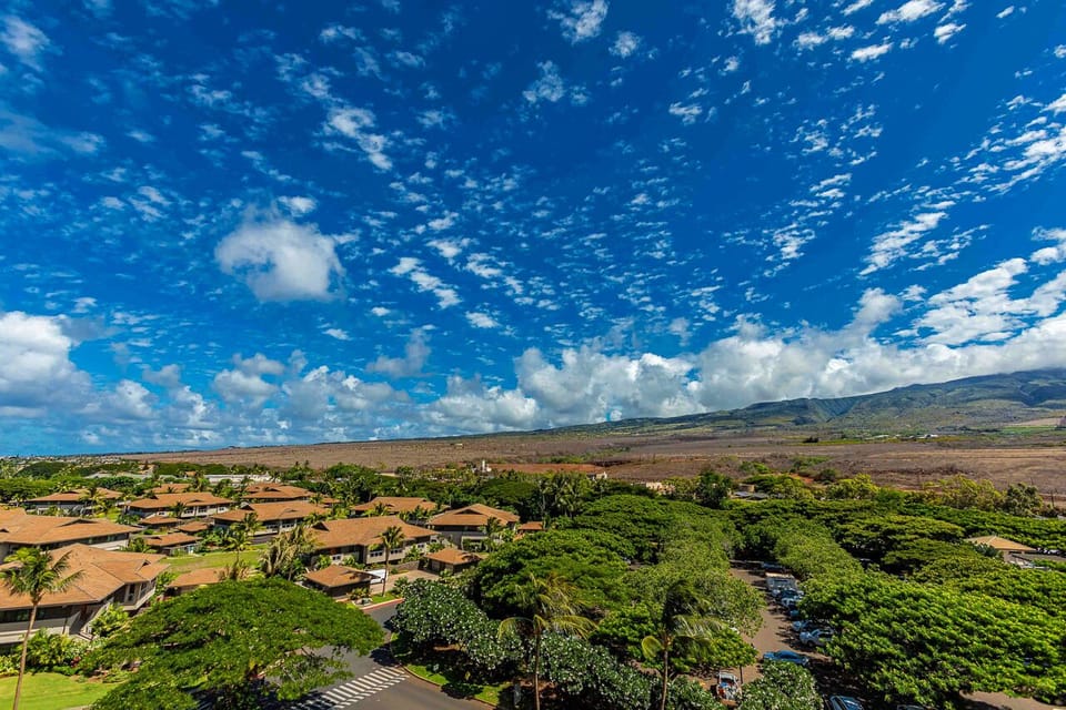 This property is nestled in a serene tropical community with lush greenery, majestic mountain vistas, and vibrant island skies overhead.
