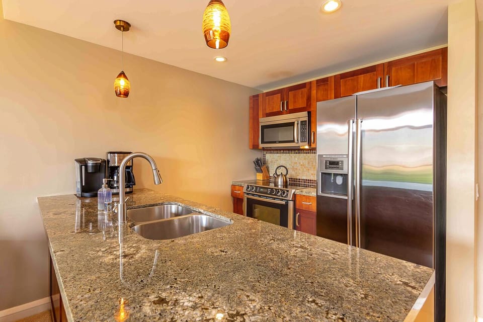 Your gourmet kitchen awaits with sparkling granite counters, stainless steel appliances, and warm wood cabinetry—perfect for brewing morning coffee or preparing a home-cooked meal during your stay.