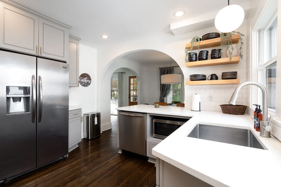 Your spacious kitchen awaits with gleaming countertops, stainless steel appliances, and charming archway views that invite memorable meals.