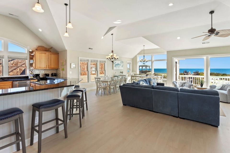 Enjoy vaulted ceilings in the spacious Living Area with a sectional couch and ocean-gazing swivel chairs.