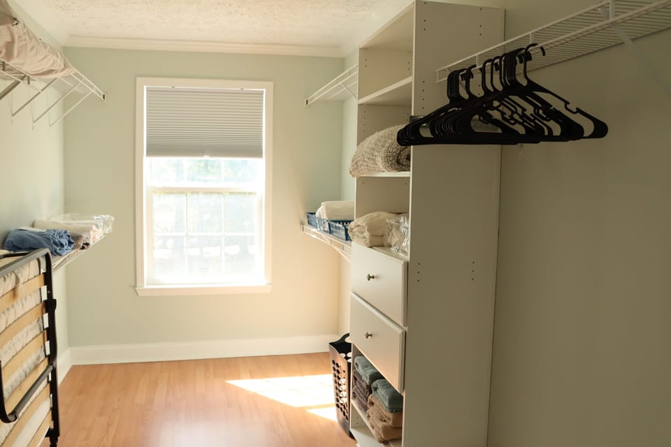 Primary walk in closet has plenty of room plus extra linens and roll away bed.
