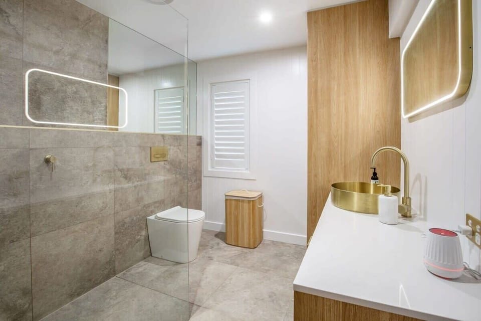 Floor to ceiling tiles and frameless glass shower recess