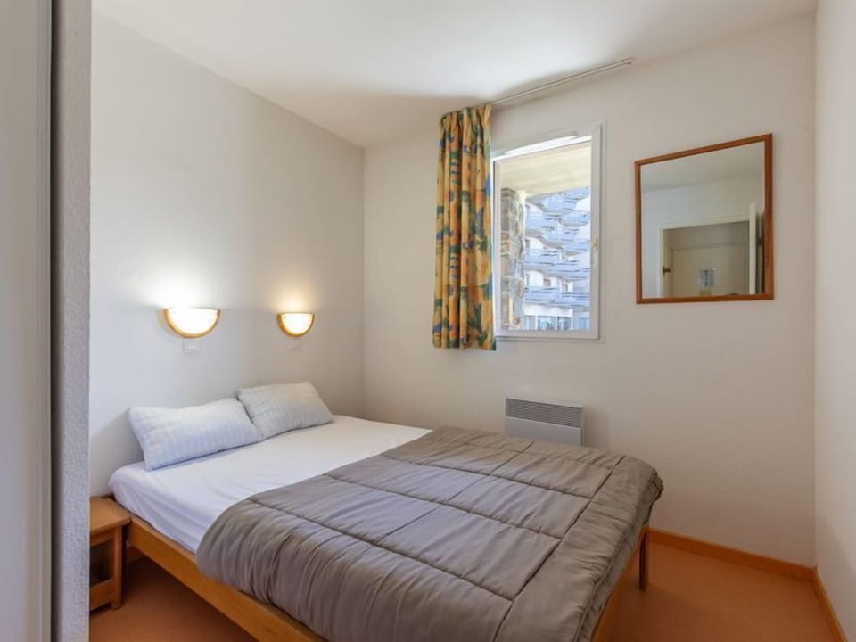 The serene bedroom offers a restful retreat, complete with natural light and cozy furnishings.