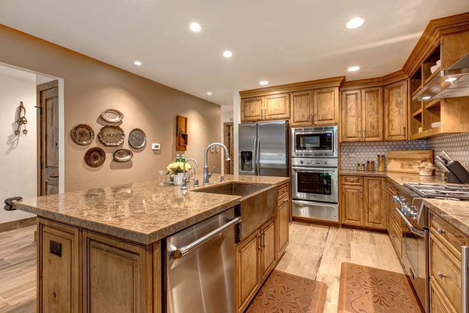 Fully Equipped Kitchen with beautiful stone countertops, hardwood floor, stainless steel Thermadore appliances, (including 3 ovens), ice maker, and island seating for three