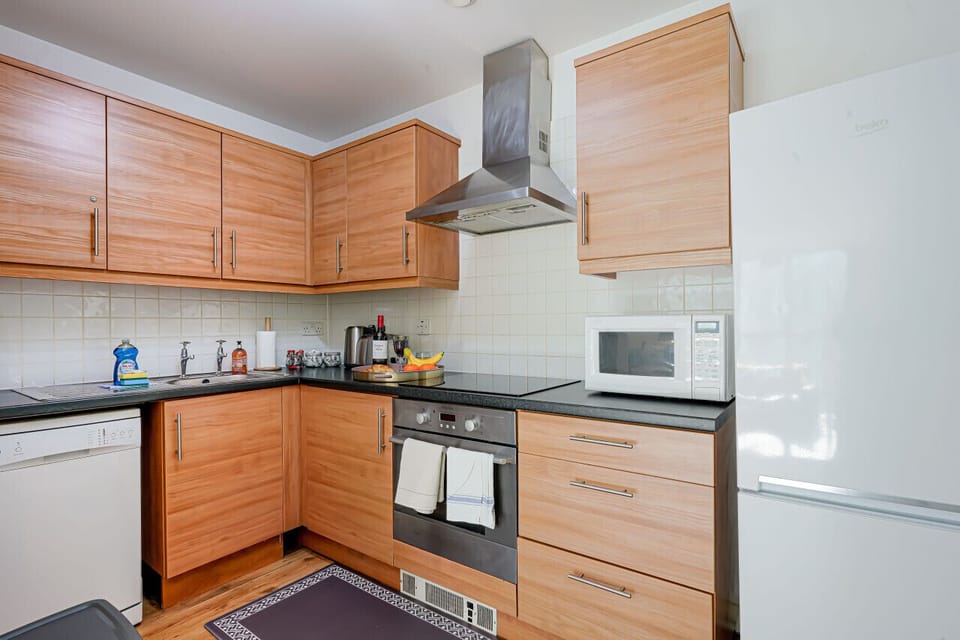 A fully equipped kitchen with fridge freezer, oven, stove, microwave, dishwasher, kettle, toaster, cookware, tableware, and utensils all provided