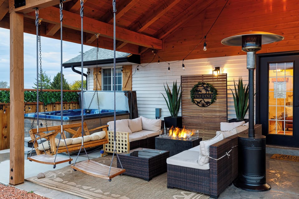 Patio sitting area with fire pit, heater, and swings