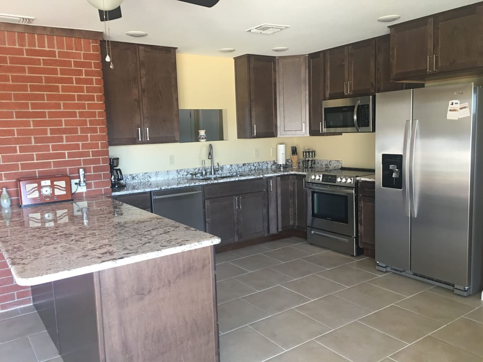 Kitchen fully stocked with utensils.   New refrigerator...has breakfast bar.