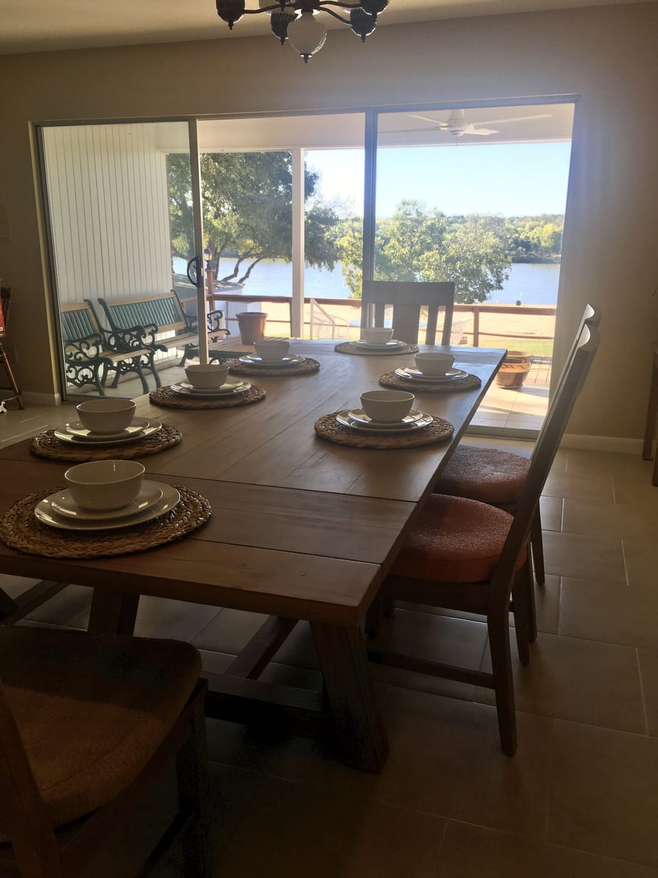 Dining table seats 7-8 people with view of lake through sliding doors.