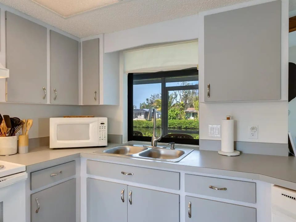 Water view from kitchen with countertop passthrough to lanai.