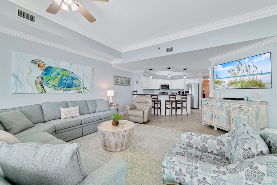 Designed for relaxation and convenience. This expansive space features a comfortable, family-sized sectional, dedicated dining seating, and a modern fully-equipped kitchen, all within a bright, airy coastal setting.