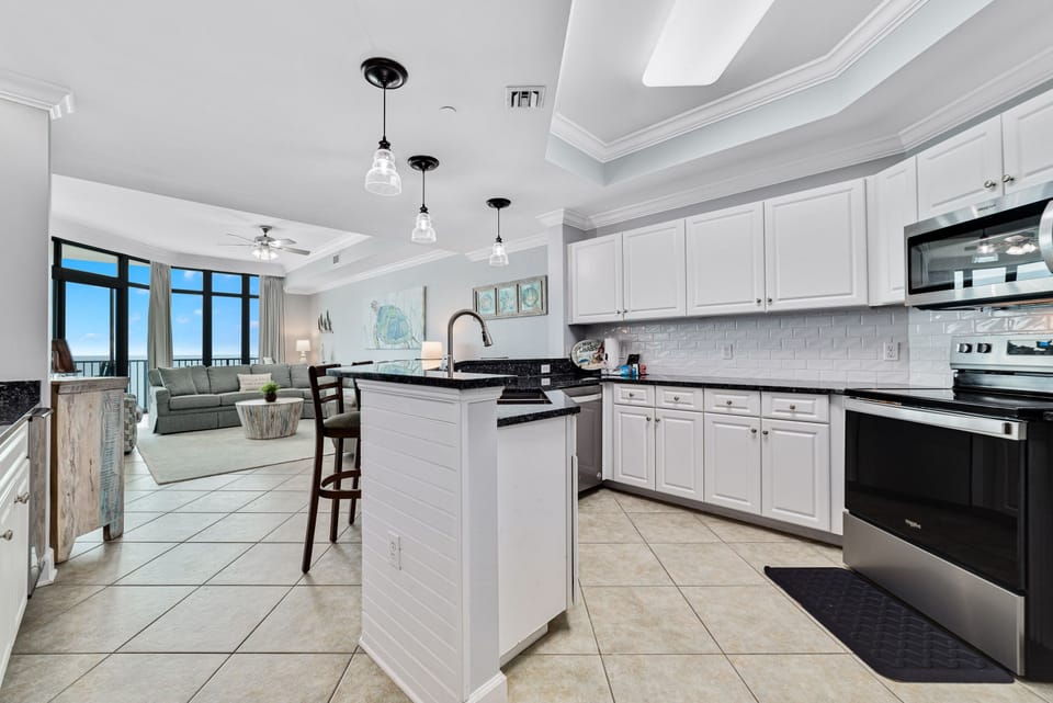 This fully functional kitchen boasts stainless steel appliances, sleek countertops, a decorative backsplash, and ample cabinet storage, ideal for everyday cooking and entertaining.