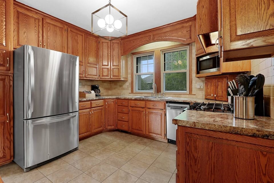 Kitchen with stainless steel appliances, tons of cabinet space, and tile floor. 