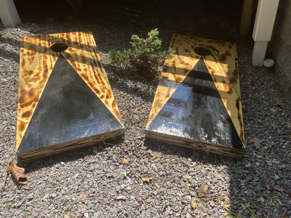 Corn hole boards stored under the porch