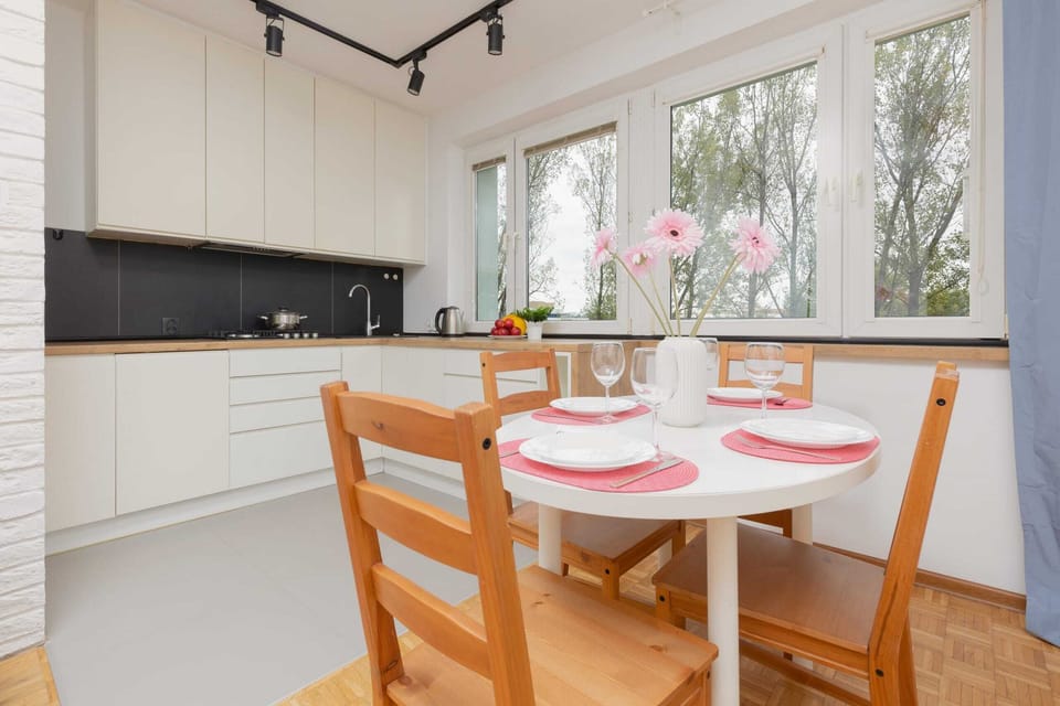 An open dining space adjacent to the fully equipped kitchen. The wooden dining table and chairs create a warm atmosphere for shared meals.

