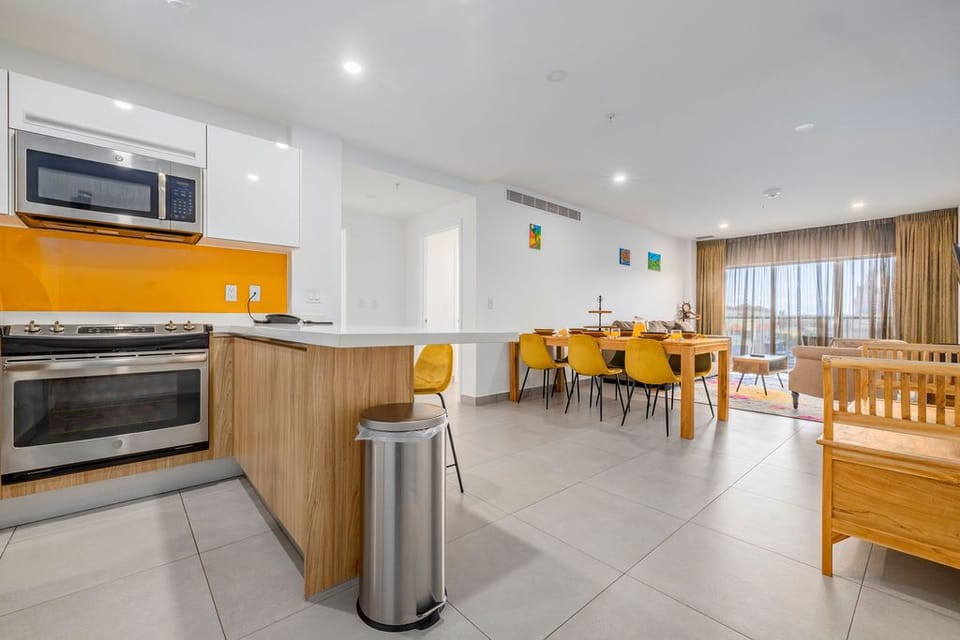 A modern fitness center spans floor-to-ceiling windows overlooking the sparkling sea, where treadmills, bikes, and weights await your waterfront workout.