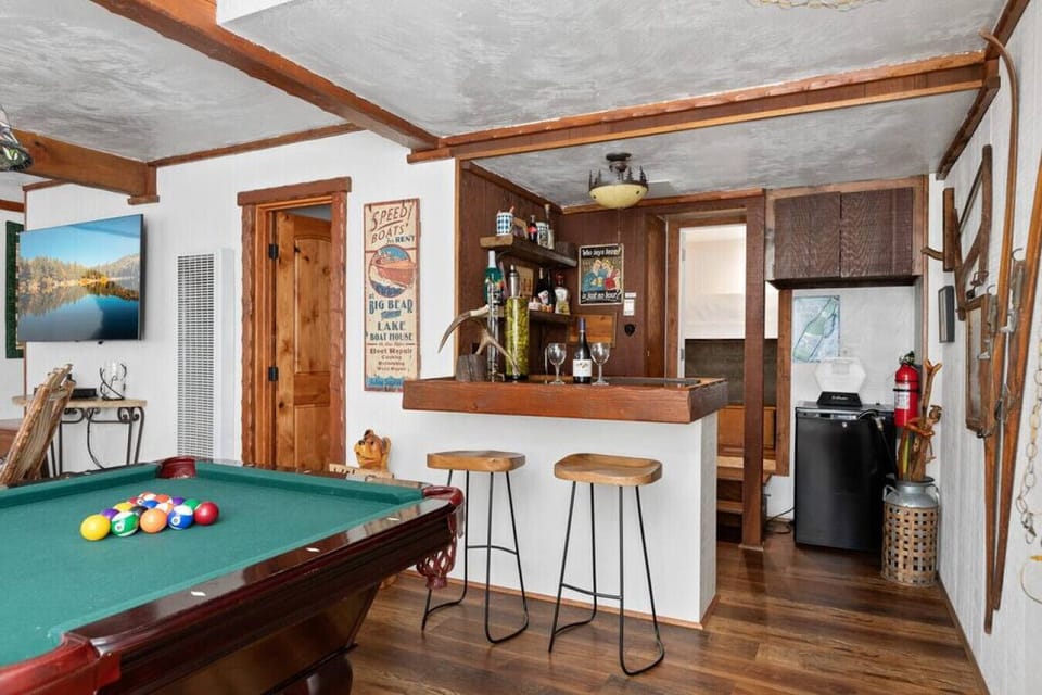 The game room features a wet bar, small beverage refrigerator, large sectional couch, pool table and 40` Smart TV.
