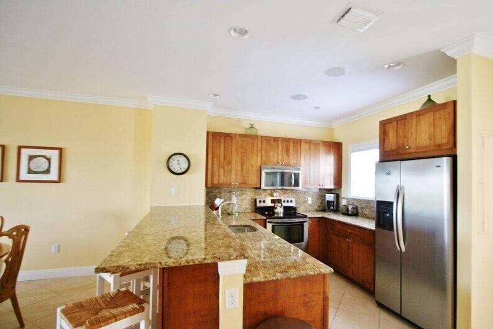 Enjoy cooking in the gourmet kitchen, equipped with modern stainless steel appliances and granite countertops.