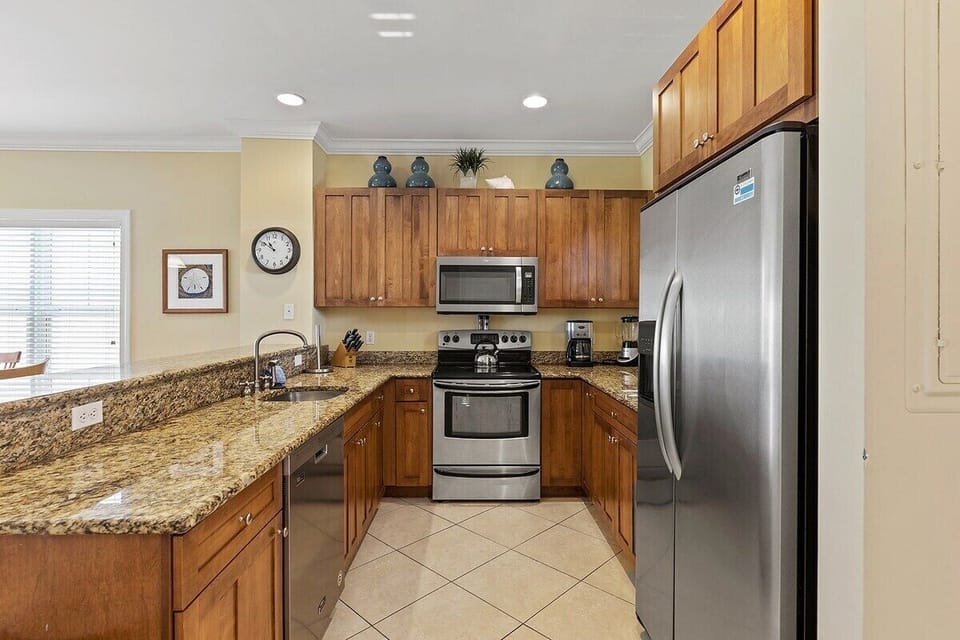 Prepare vacation meals using stainless-steel appliances, wood cabinetry, granite countertops, and generous preparation space.