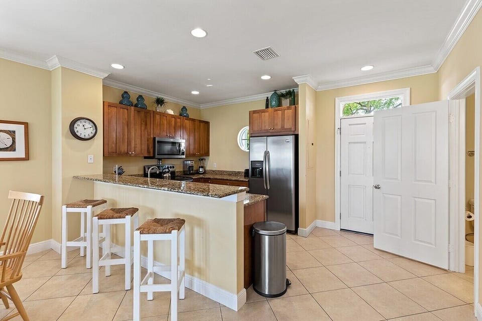The open kitchen offers bar seating, full-size appliances, and an easy connection to the home's social spaces.