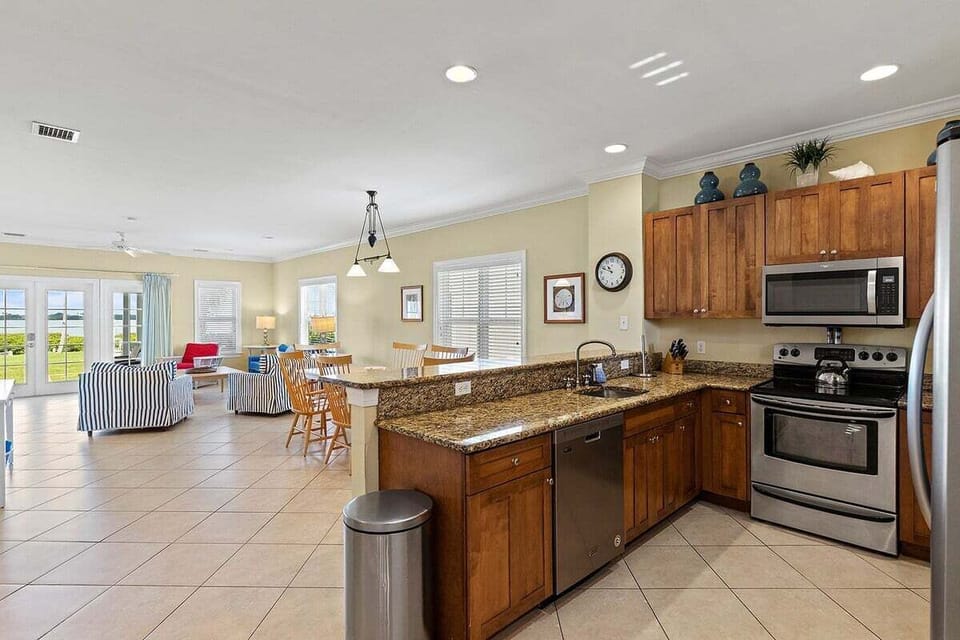 The fully equipped kitchen connects effortlessly to the dining and living spaces, creating an inviting setting for group gatherings.