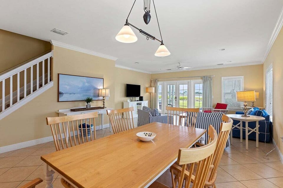 Gather around the large wooden dining table with easy access to the open kitchen, living room, and outdoor porch.