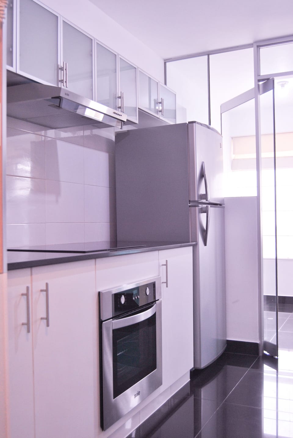 Minimalistic kitchen with refrigerator, extractor hood