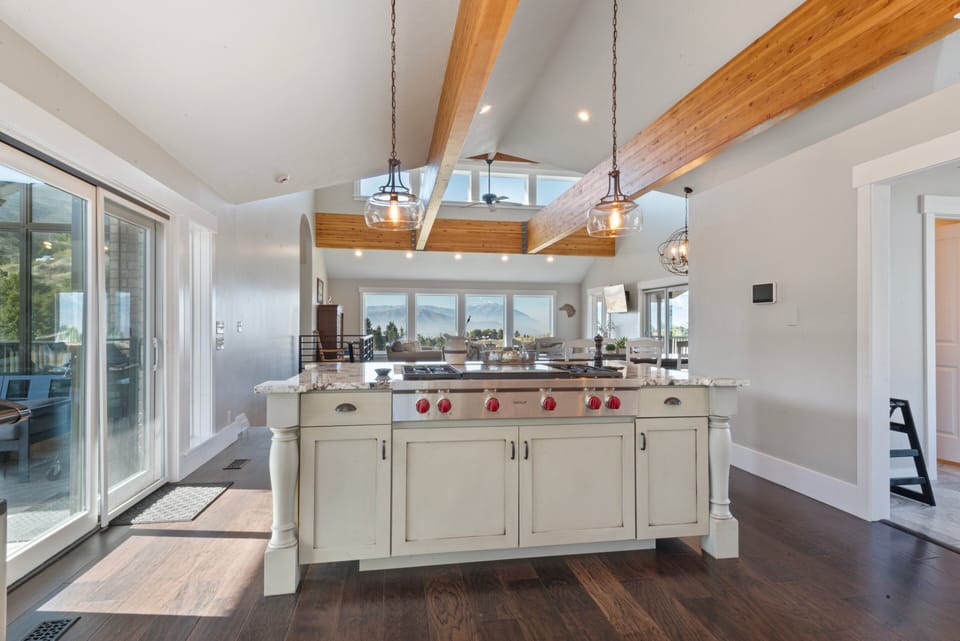 A massive Wolf professional gas range on the large kitchen island open to the great room.
