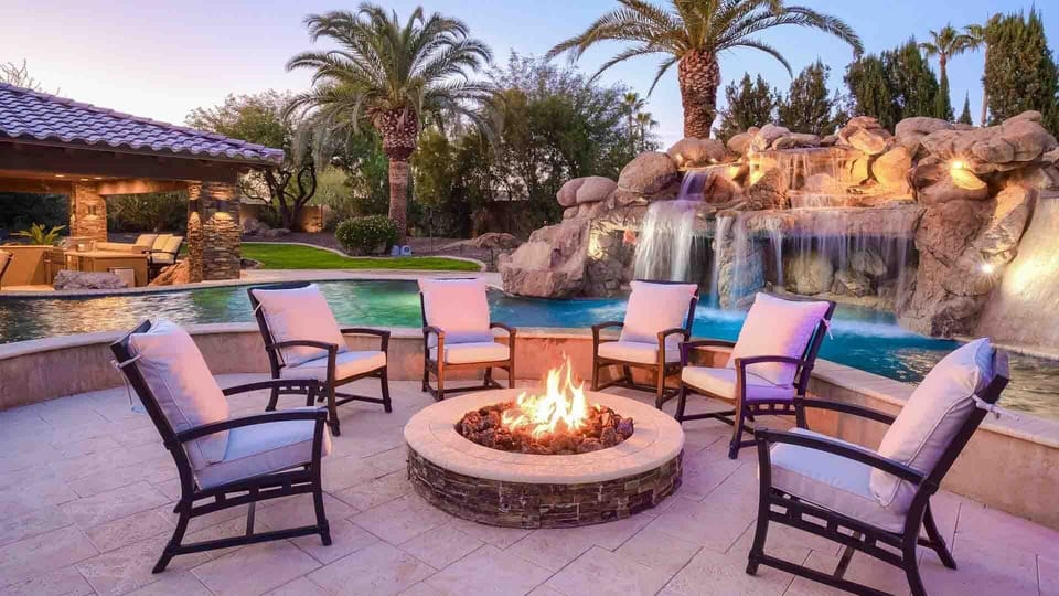 Cozy firepit along the lazy river & waterfall across from the spa