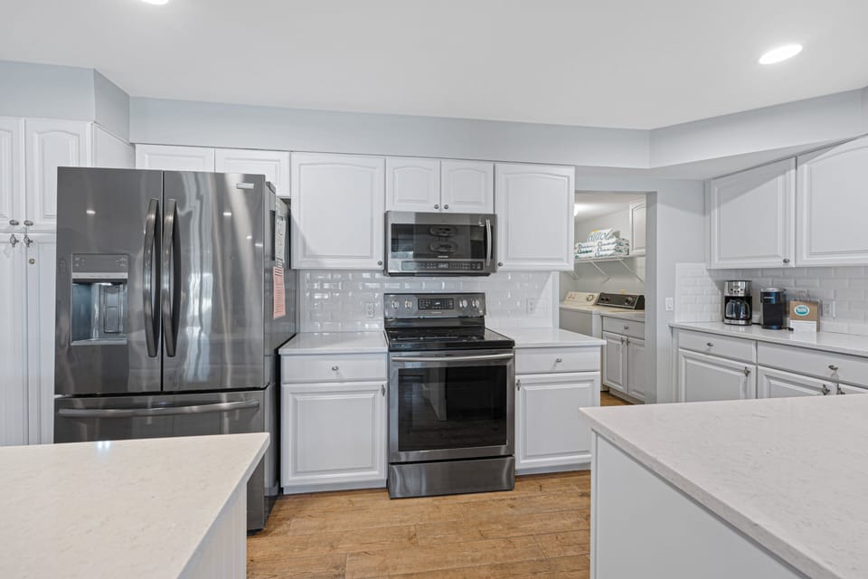 Sleek and functional kitchen featuring sleek countertops, stainless steel appliances, and crisp white cabinetry