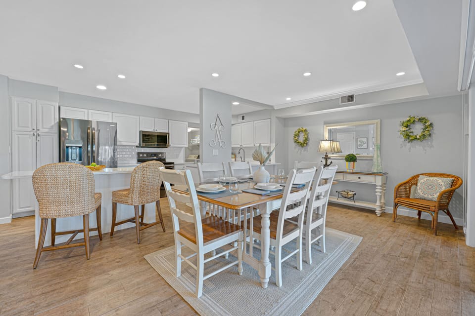 Warm wood floor and a comfortable living area beyond create an inviting space that flows effortlessly for entertaining, family meals, or unwinding after a day on the island.