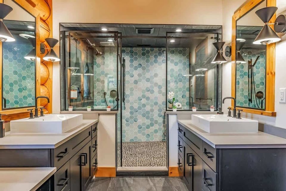 Modern bathroom with dual vessel sinks, hexagonal tile backsplash, and walk-in shower.