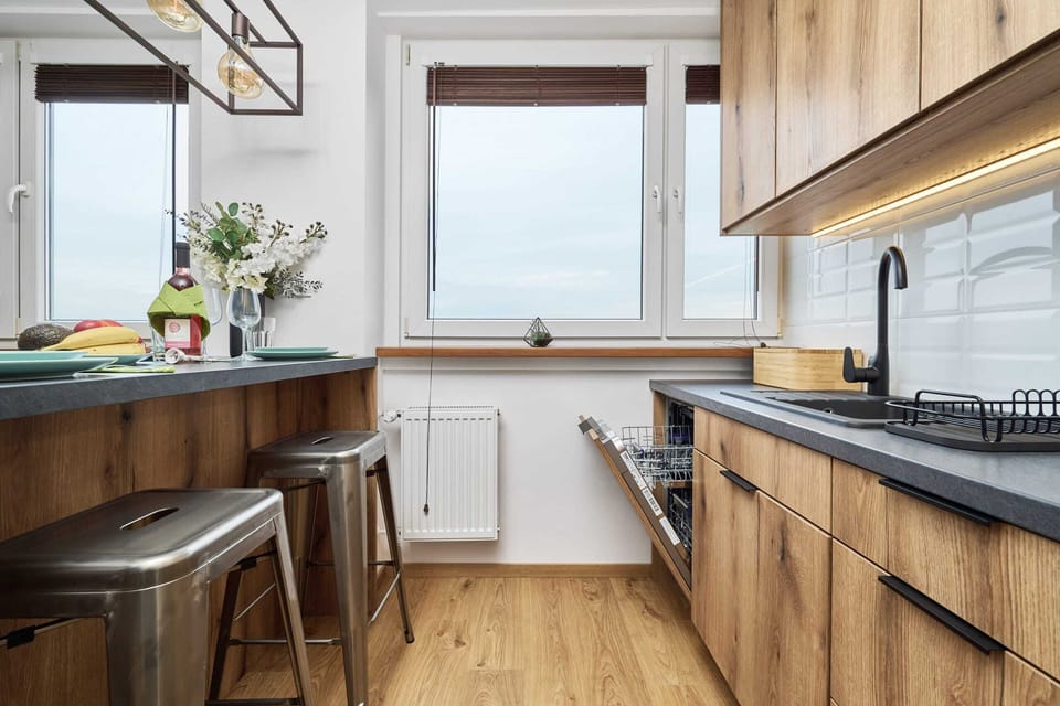 The kitchen area with wooden cabinetry, modern appliances, and a cozy atmosphere.

