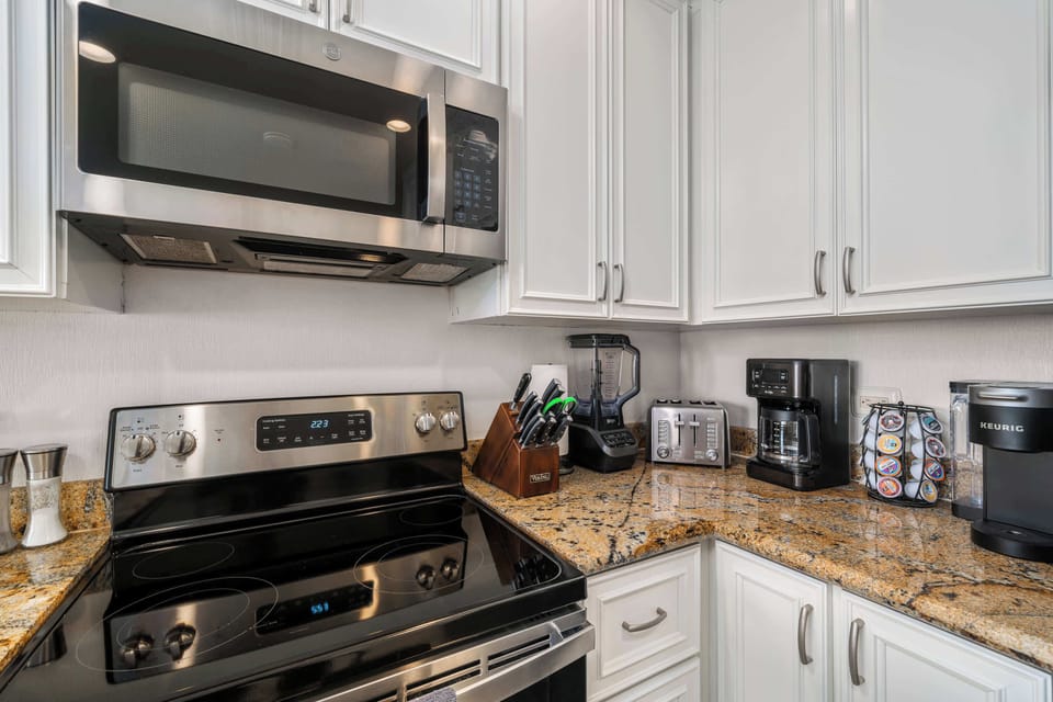 Fully equipped kitchen with stainless steel appliances, coffee station, and cookware.