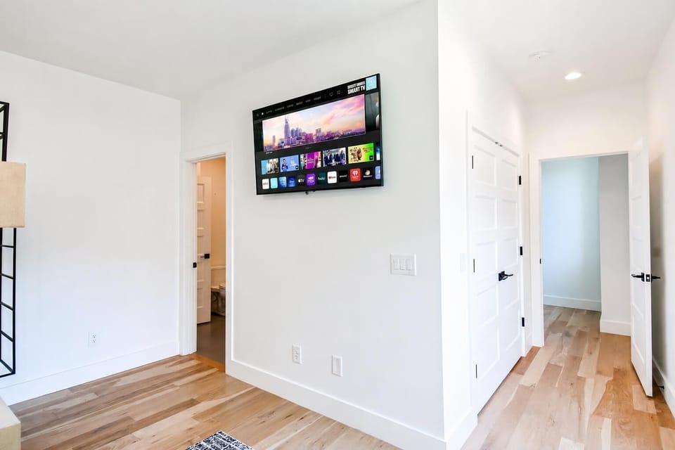 Each bedroom gets its own custom personality, with wall-mounted TVs and hardwood floors throughout. Book your stay with Misfit Homes to sleep 10 in real comfort