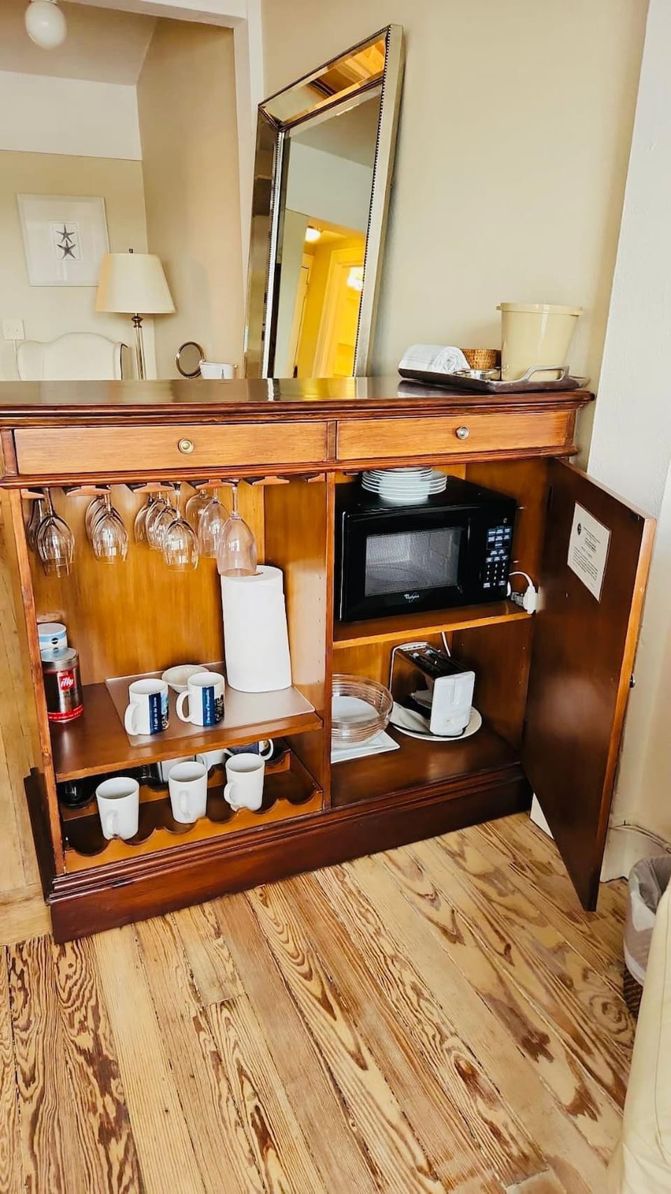 Fully stocked kitchenette with glasses, plates, and cutlery