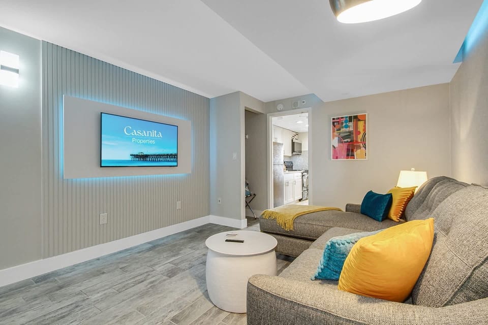 Relax in this cozy, living area featuring a plush sectional, accent lighting, and a Smart TV for entertainment. The soothing decor and comfortable seating make it an ideal spot to unwind after a day of exploring.