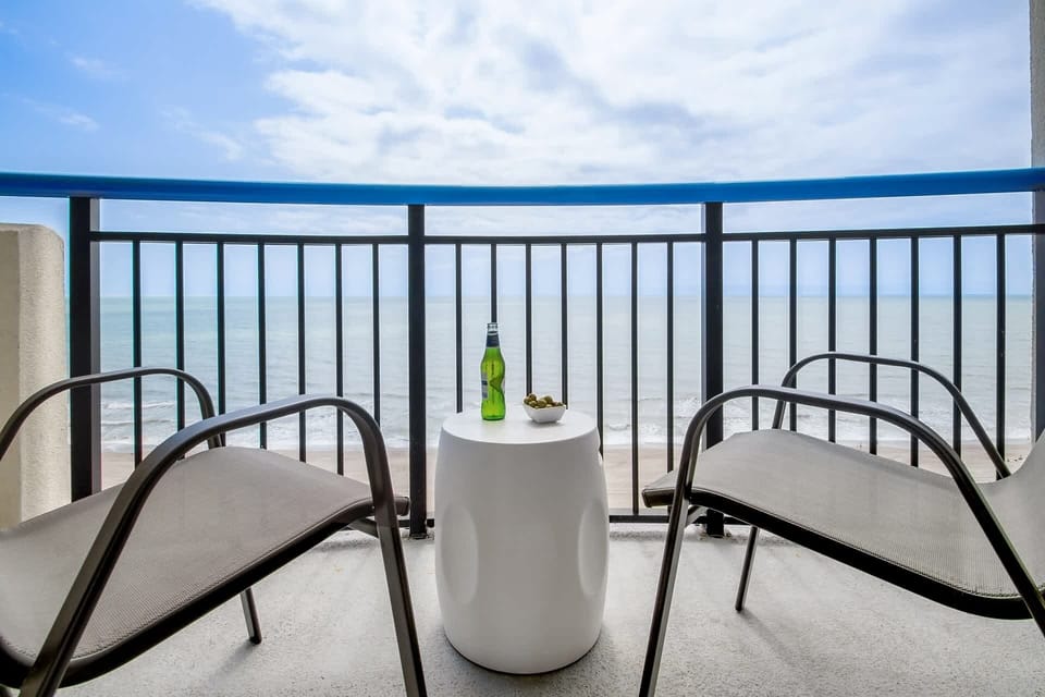 Step out onto your private balcony and soak in panoramic ocean views. With comfortable seating and a side table perfect for snacks or drinks, this serene spot invites you to unwind and enjoy the gentle sea breeze and the calming sound of the waves.