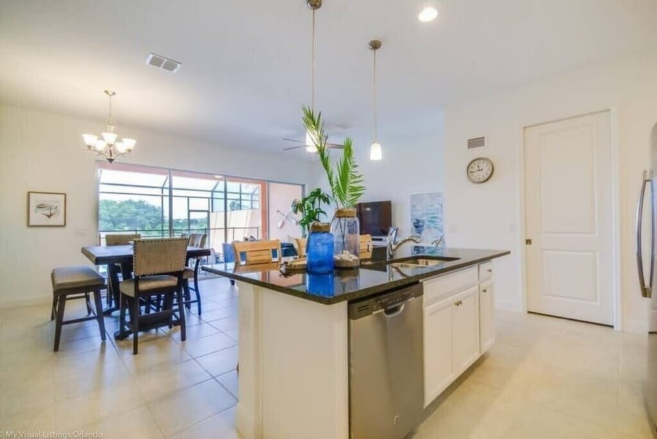 - Open kitchen and dining area with island sink and modern lighting
- Functional layout ideal for group meals and easy entertaining
- Myrtle Beach vacation rental with open concept kitchen dining  