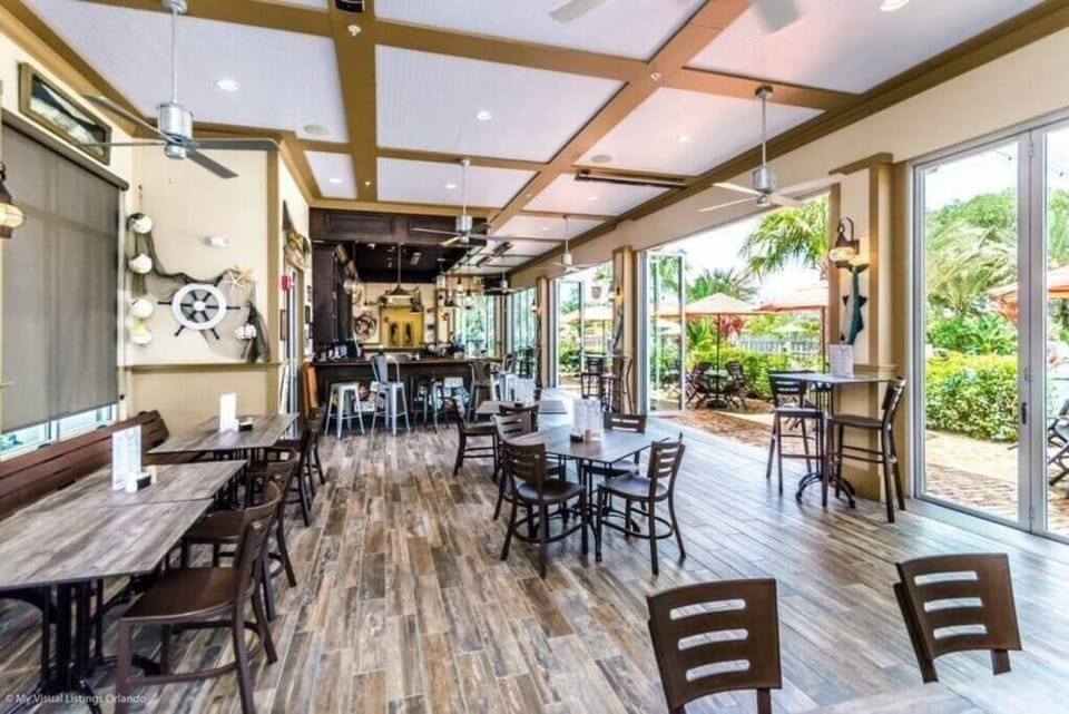 - Resort clubhouse with dining tables open seating and social space
- Community gathering area perfect for meals work or relaxing
- Myrtle Beach vacation rental clubhouse with indoor outdoor flow  
