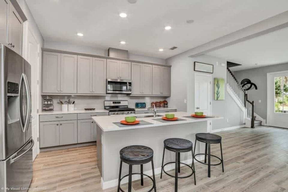 - Modern kitchen with island seating, stainless appliances, and full cookware  
- Open kitchen layout ideal for meals, snacks, and group conversations  
- Clean design with bright lighting, storage space, and dining stools  