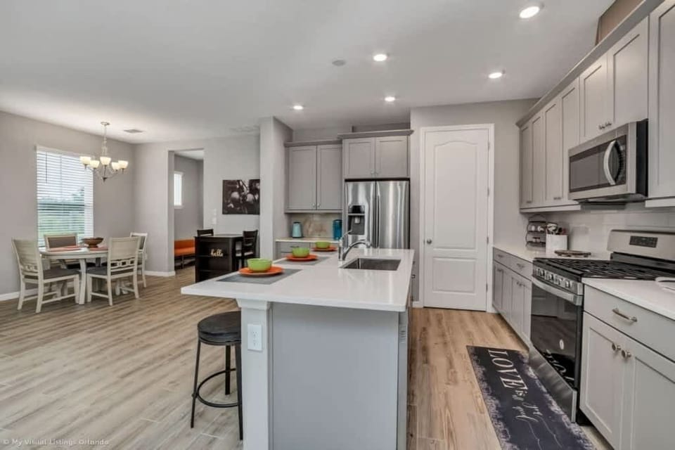 - Wide kitchen view with island counter, full appliances, and dining access  
- Functional cooking area perfect for family meals and group stays  
- Open concept design connecting kitchen, dining, and living zones  
