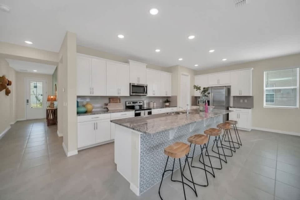 - Modern kitchen with large island seating and full appliances for meals
- Open kitchen layout ideal for groups cooking together and hosting nights
- Clean bright design with plenty of storage prep space and bar stools 