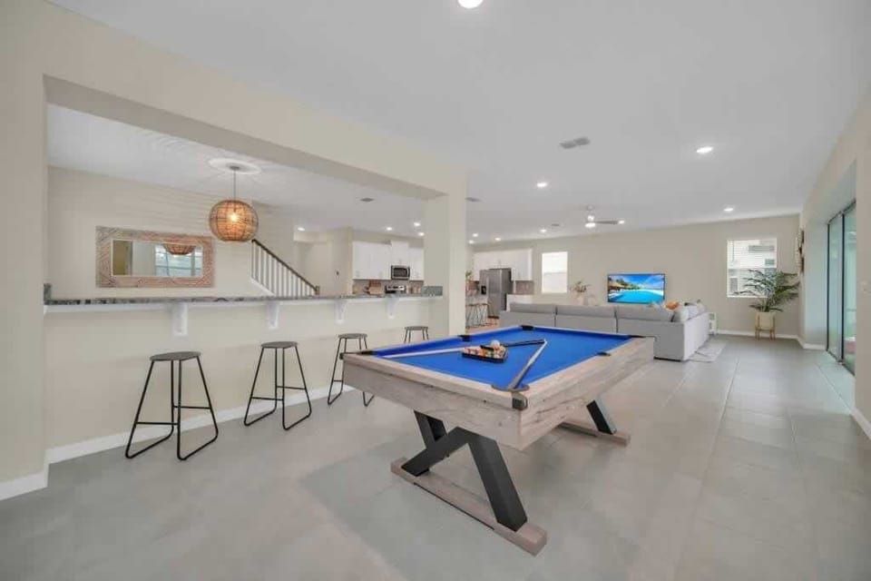 - Game room with pool table extra seating and open living space nearby
- Fun indoor area for family games casual evenings and group hangouts
- Open layout connects kitchen lounge and entertainment zones smoothly  
