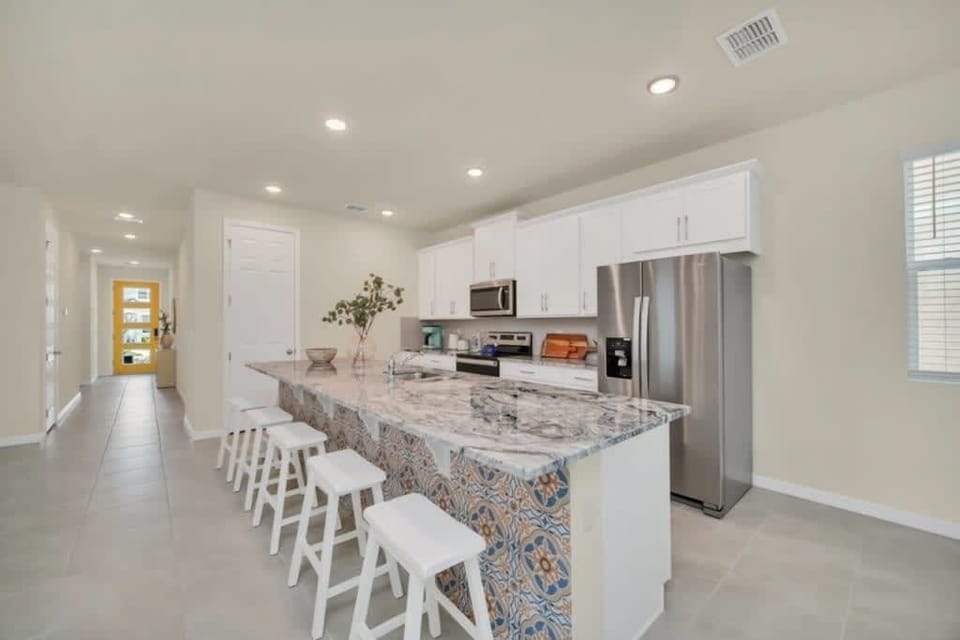 - Large kitchen island with bar seating
- Fully equipped modern kitchen for group meals
- Bright open space perfect for hosting together