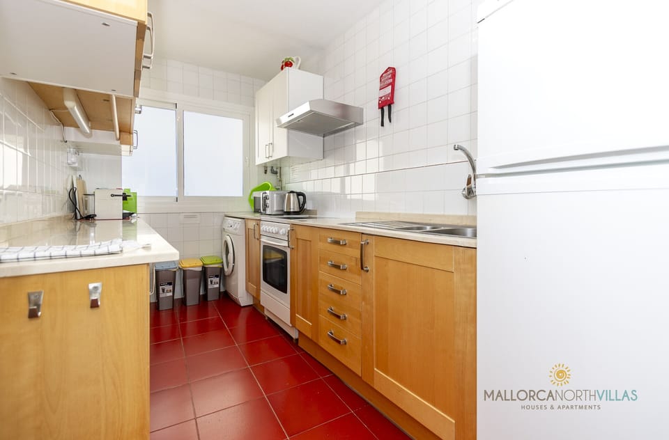 Fully equipped kitchen with appliances, spacious countertop and natural light in the Port de Pollença apartment.