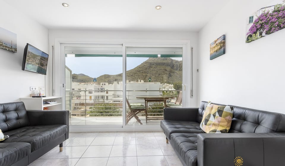 Bright and spacious living room with two sofas and balcony access with mountain views in Port de Pollença
