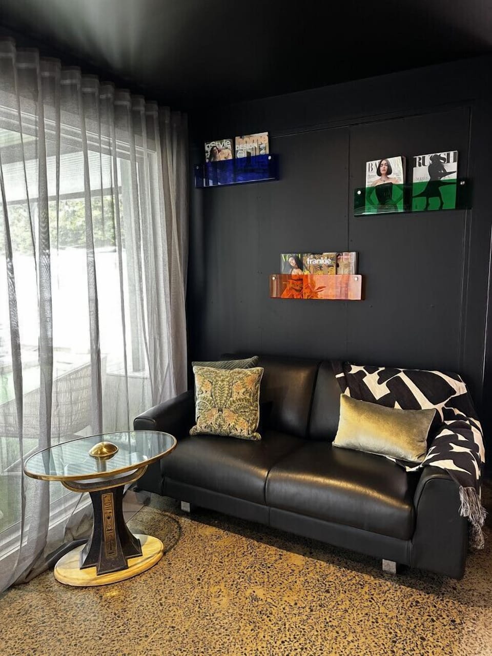 Magazines for you to read and a comfy leather couch to watch the super large 85 inch TV screen.